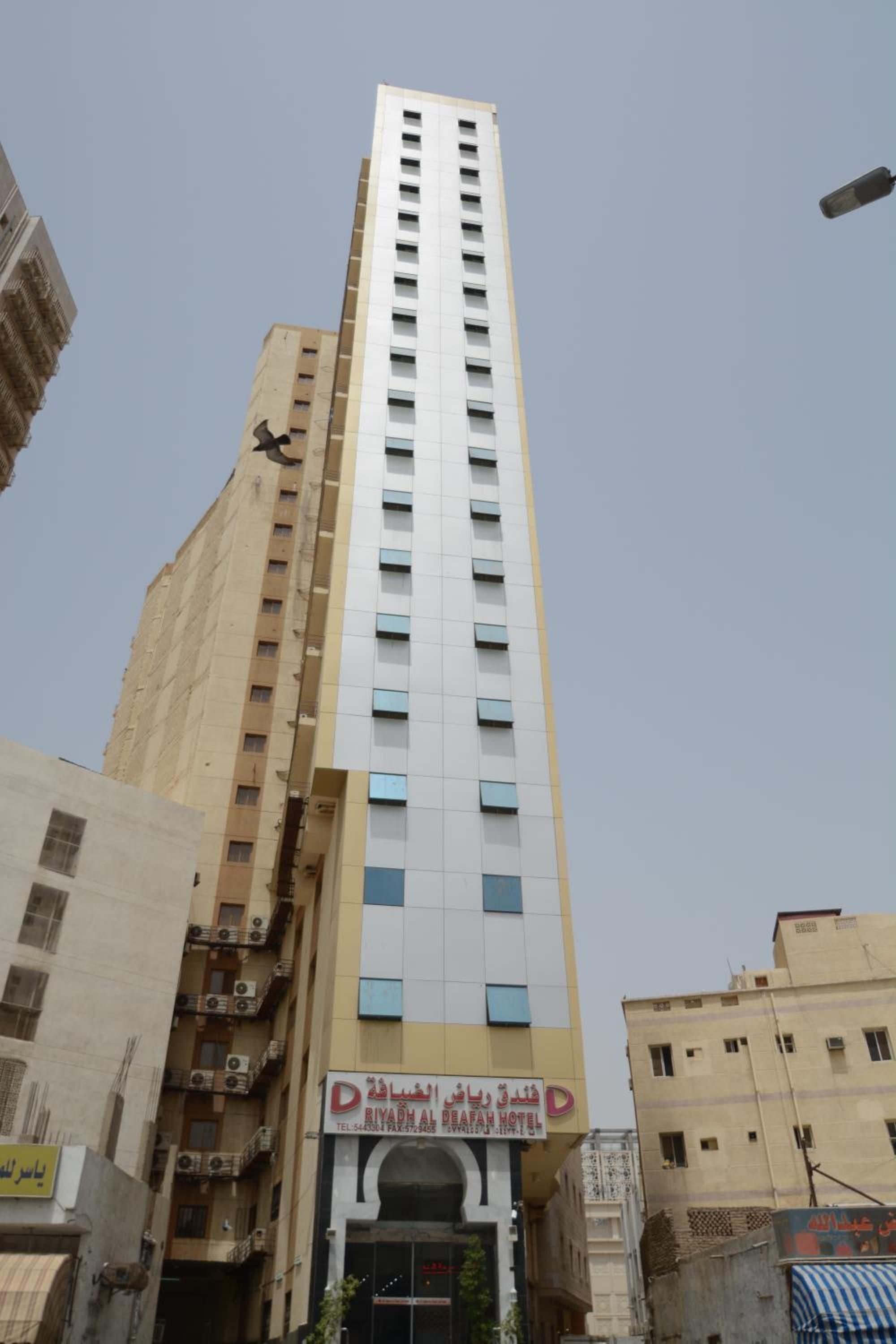 A tall hotel building with a sign for Riyadh Al Fareah Hotel.