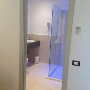Ein modernes Badezimmer mit Glasdusche, Waschbecken und Toilette.