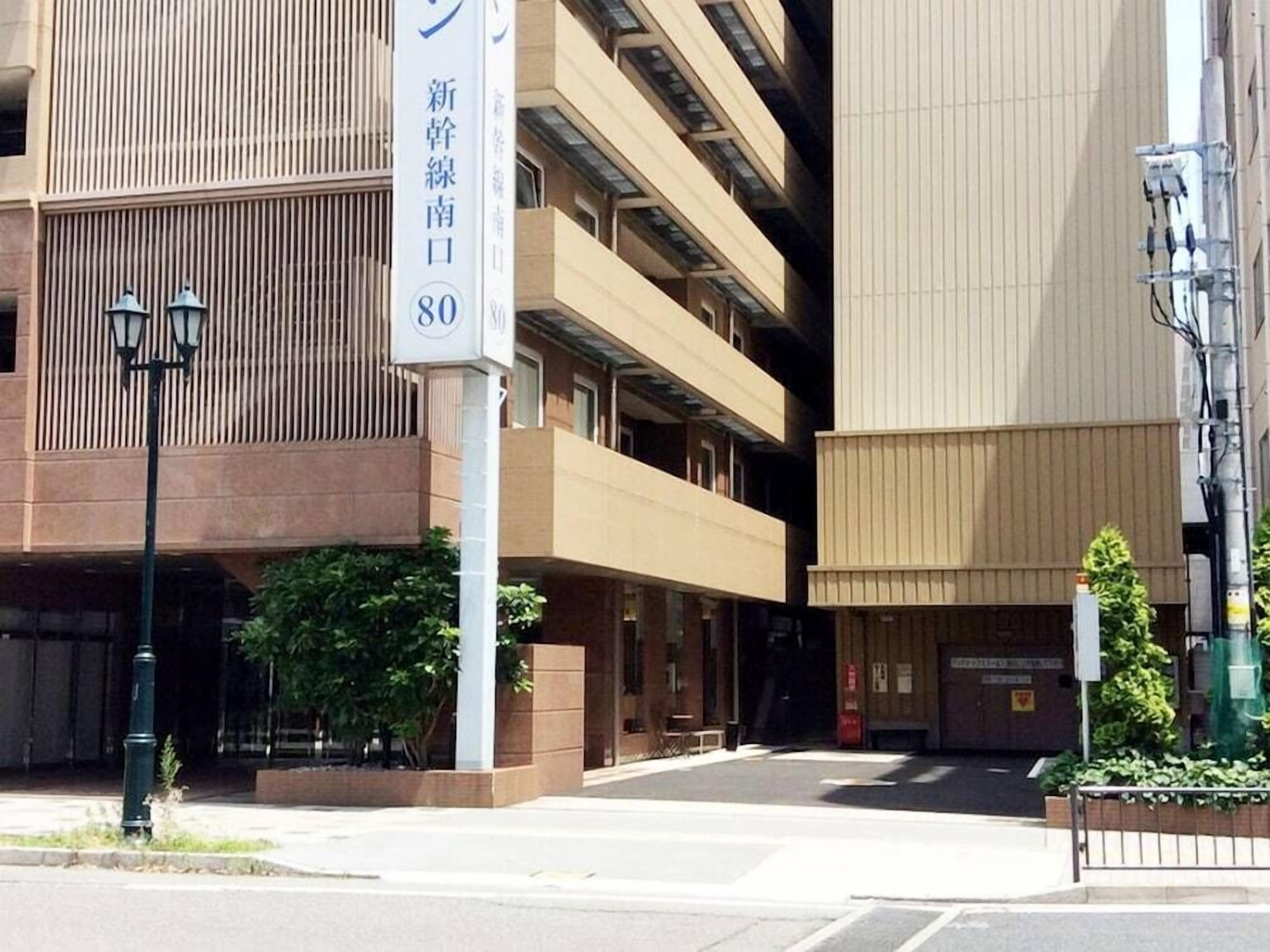 Un edificio de varios pisos con un cartel que indica una entrada nueva.