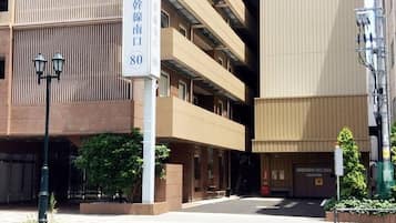 Un edificio de varios pisos con un cartel que indica una entrada nueva.