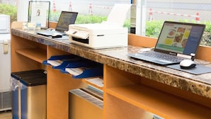 Ein Empfangstresen mit zwei Laptops, einem Drucker und einem Bildschirm.