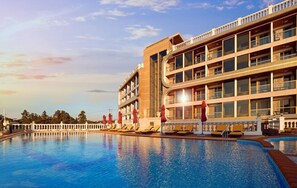 A hotel with a large swimming pool, multiple balconies, and a modern architectural design. - Goldone Hotel and Suites (Seogwipo)