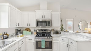 A modern kitchen with white cabinets, a stainless steel microwave, a gas stove, and a built-in oven. - Bombay Chardonnay by Avantstay Covered Pavilion + BBQ Quiet Paso Hillside + Vineyards View (Paso Robles)