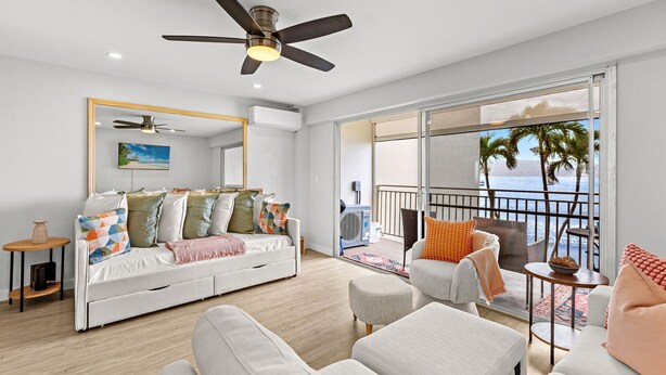 A modern living room with a sofa, armchairs, and a balcony with a view of the ocean. - New Listing! Ocean Front Gem in Lahaina (Lahaina)