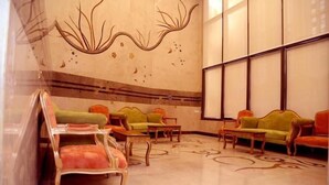 A lobby with a large window, a patterned carpet, and several sofas and chairs. - Al Bostan Al Masi Hotel (Makkah)