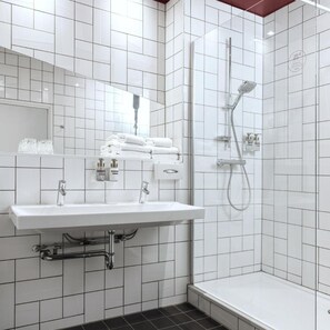 A modern bathroom with a white sink, mirror, and shower. - Mabi Hotel Centrum (Maastricht)