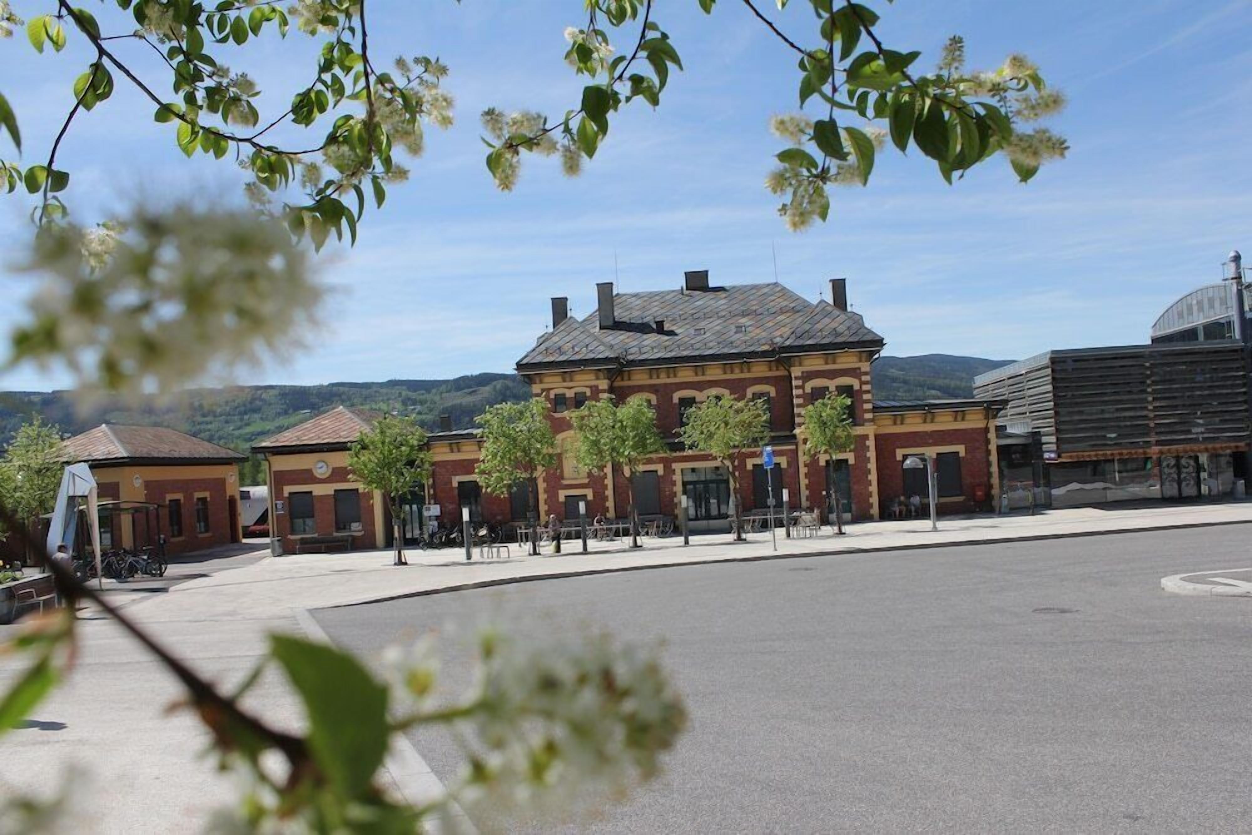A historic building with a red brick facade, a central courtyard, and a view of the surrounding landscape.