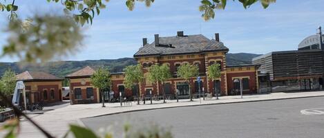 A historic building with a red brick facade, a central courtyard, and a view of the surrounding landscape.