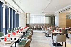 A modern dining area with long tables, chairs, and pendant lighting. - Courtyard By Marriott Osaka Honmachi (Osaka)