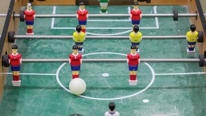 A tabletop football game with miniature figures on a green field, a ball in play, and a referee figure. - Rest Night Hotel Suites Al Hamra (Riyadh)