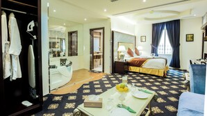 A hotel room with a bed, a sitting area with a table set for dining, a bathroom with a mirror and a shower, and a wardrobe. - Rest Night Hotel Suites Al Hamra (Riyadh)