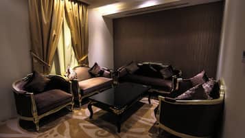 A room with a sofa set, a coffee table, and a patterned carpet.