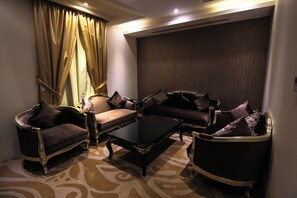 A room with a sofa set, a coffee table, and a patterned carpet. - Rest Night Hotel Suites Al Hamra (Riyadh)