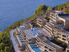 Un complexe hôtelier doté de plusieurs piscines, de balcons et offrant une vue sur la mer.