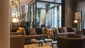 A modern living room with a sofa set, a glass coffee table, and decorative lighting. - Harbr Hotel Konstanz (Konstanz)