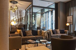 A modern living room with a sofa set, a glass coffee table, and decorative lighting. - Harbr Hotel Konstanz (Konstanz)