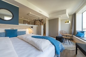 A modern hotel room with a large bed, a desk, a chair, and a window with a view. - Harbr Hotel Konstanz (Konstanz)