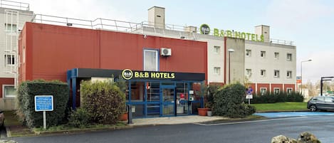 Ein Bed and Breakfast Hotel mit blauer Fassade, einem Schild für kostenlose Parkplätze und einem barrierefreien Eingang.