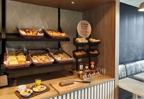 A breakfast buffet with bread, pastries, and condiments. - B&B Hotel Cergy Pierrelaye (Pierrelaye)