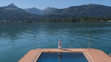 Ein Schwimmbecken mit Blick auf Berge und ein Gewässer.