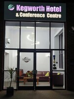 Exterior del Hotel & Centro de Conferencias Kegworth, con fachada de vidrio moderna, una zona de recepción con asientos y el logotipo a la vista.