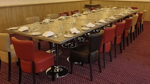 A conference room with a long table set for a meeting, surrounded by chairs, and equipped with wall-mounted lighting. - Kegworth Hotel & Conference Centre (Derby)