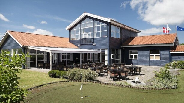 A two-story building with a covered patio area and outdoor seating. - Sleep2night (Helsingor)