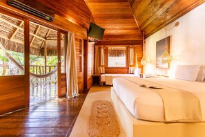 Une pièce en bois avec un lit, une télévision et un hamac.