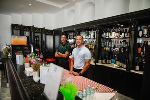 A bar area with a checkered tablecloth, a coffee machine, and a variety of bottles on shelves. - Blumar Resort and Spa (Hammamet)