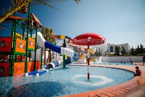A water park with a large pool, colorful slides, and a red umbrella structure. - Blumar Resort and Spa (Hammamet)