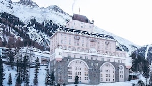 A large, multi-story building with a central tower, surrounded by snow-covered mountains. - Hotel Schloss Pontresina Family Spa (Pontresina)