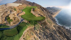 An aerial view of a coastal golf course with a winding path, green fairways, and a beach in the background. - Montecristo 3-bedroom house with AC , pool in Cabo San Lucas (Cabo San Lucas)