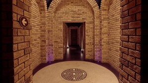 A brick-walled corridor with a circular patterned floor and a directional arrow sign. - Montecristo 3-bedroom house with AC , pool in Cabo San Lucas (Cabo San Lucas)