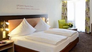 A hotel room with a bed, a desk, a chair, and a painting on the wall. - Waldachtal Business Balance (Waldachtal)