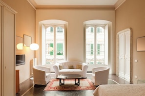 A hotel room with a sofa, armchairs, a coffee table, and a bed. - Locanda di Palazzo Cicala (Genoa)