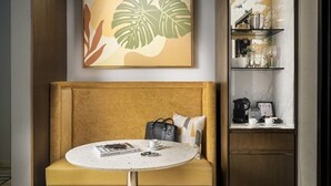 A compact hotel room with a sofa, a small round table, and a wall-mounted shelf with glassware. - Relax in Style at Luxury Beachfront Escape at Villa Del Palmer
5-Star Oceanfront (Cancún)