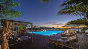 A poolside area with lounge chairs and a pergola with curtains. - Lalibay Resort & Spa - Adults Only (Aegina)
