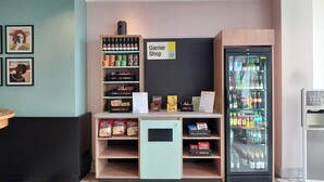 Een snackbar met diverse snacks en dranken, een bord met Garner Shop erop, en een koeltoog.