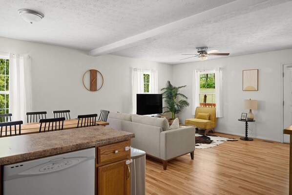 A spacious living area with a dining table, sofa, and a ceiling fan. - Peaceful Bryce Cabin + Hot Tub + Fire Pit + Pets - 3 BR + Loft (Mount Jackson)