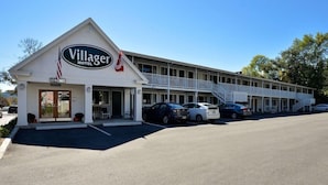 A motel with a prominent sign, a covered walkway, and a parking lot. - Bar Harbor Villager Motel (Bar Harbor)