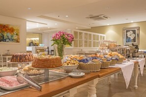 Ein reichhaltiges Buffet mit verschiedenen Speisen, einer Torte und einer Blumenvase.