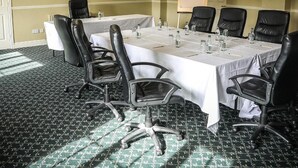 A conference room with a long table, black chairs, a white tablecloth, and a flat-screen TV on the wall. - Springfort Hall Hotel (Mallow)
