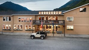 A Westmark Inn with a two-story structure, a covered front porch, and a mountain backdrop. - Westmark Inn Skagway (Skagway)