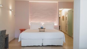 A large bed with a headboard, a small side table, and a chair. - Coquillade Village (Gargas)