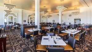 A spacious restaurant with high ceilings, modern lighting, and a patterned carpet. Tables are arranged in a casual layout with booths and individual seating. - Mammoth Hot Springs (Yellowstone National Park)