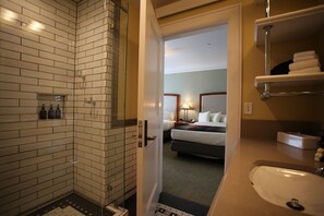 A hotel bathroom with a shower, a sink, and a mirror. - Mammoth Hot Springs (Yellowstone National Park)