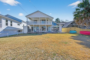A two-story house with a balcony, a covered porch, and a fenced yard.