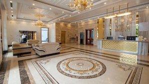 A luxurious lobby with a grand chandelier, plush seating, a reception desk, and a marble floor with intricate designs. - Vela Luxury Hai Ha Hotel  (Quang Ha)