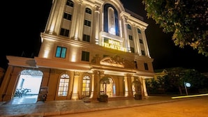 A historic building with a grand entrance, large windows, and a prominent sign indicating it is a hotel. - Vela Luxury Hai Ha Hotel  (Quang Ha)