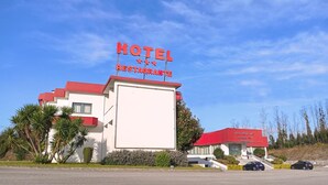 Ett hotell med ett rött tak och en skylt där det står ”HOTEL RESTAURANG”.